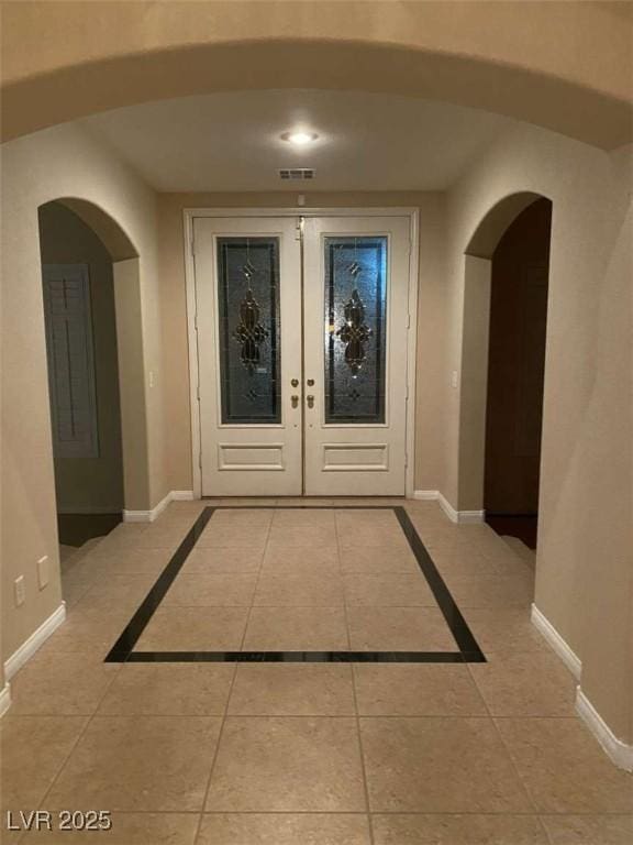 9301 Harrow Rock St, Las Vegas, NV 89143 - entrance foyer featuring french doors, baseboards, arched walkways, and light tile patterned floors