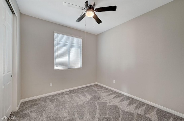 carpeted spare room featuring a ceiling fan and baseboards