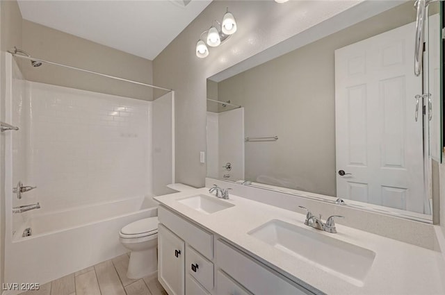 bathroom with double vanity, washtub / shower combination, toilet, and a sink