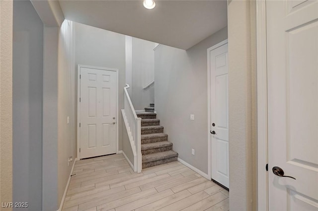 staircase with baseboards and wood finished floors