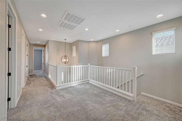 carpeted empty room with recessed lighting, visible vents, baseboards, and a chandelier