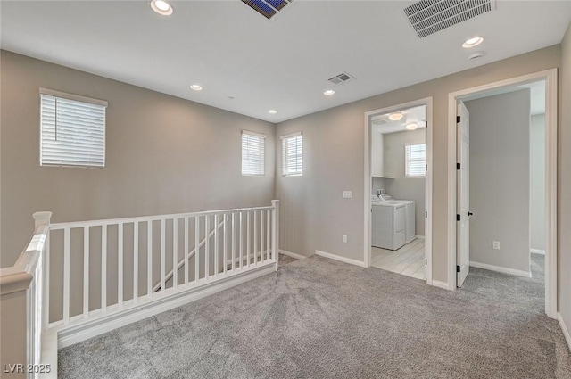 carpeted empty room featuring recessed lighting, visible vents, and independent washer and dryer