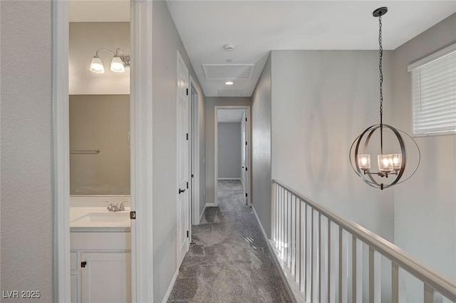 hall with baseboards, dark colored carpet, and a sink