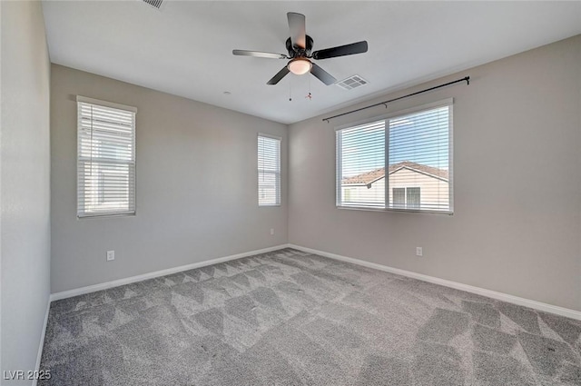 empty room with a ceiling fan, visible vents, carpet, and baseboards