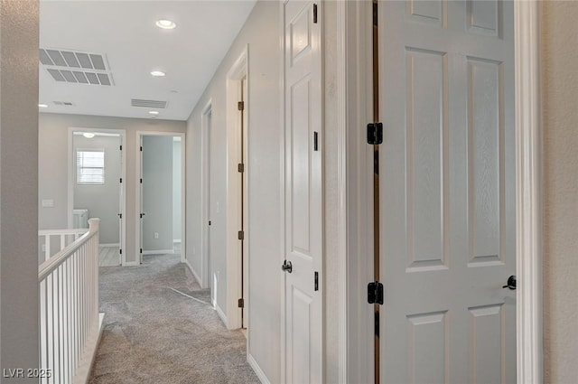 corridor featuring recessed lighting, baseboards, visible vents, and light carpet