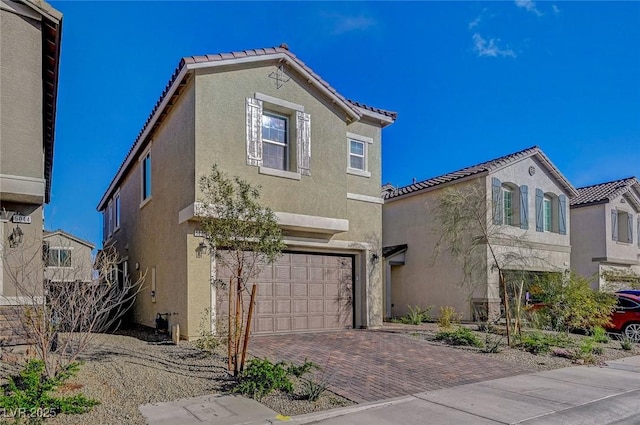 mediterranean / spanish-style home featuring decorative driveway, a garage, and stucco siding