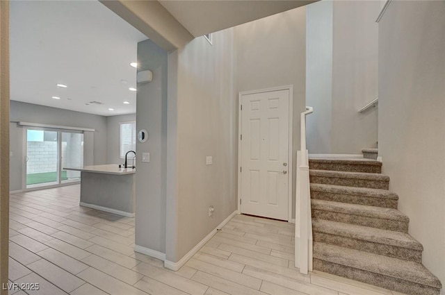 stairway featuring recessed lighting, baseboards, and wood finish floors