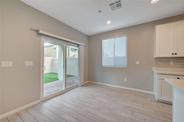 unfurnished dining area with recessed lighting, baseboards, visible vents, and light wood-type flooring