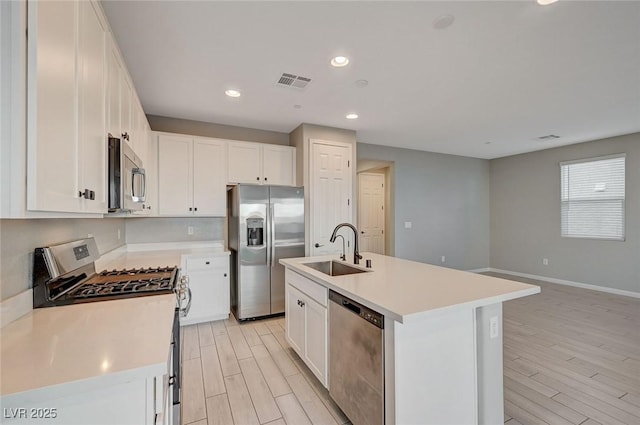 kitchen with visible vents, light wood-style flooring, appliances with stainless steel finishes, and a sink