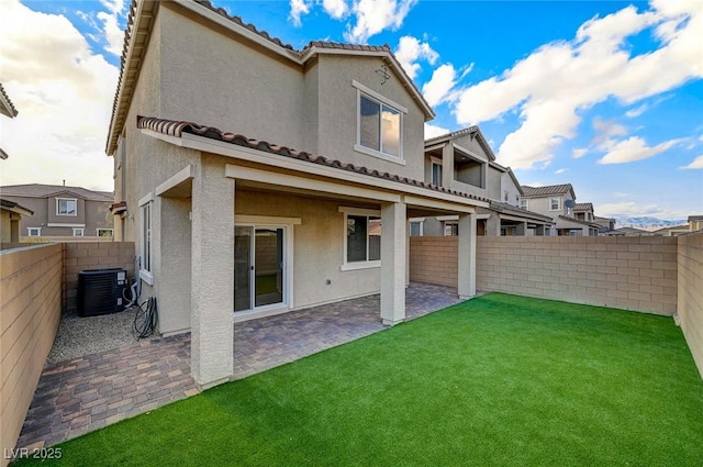 back of property featuring a yard, a fenced backyard, stucco siding, central air condition unit, and a patio area