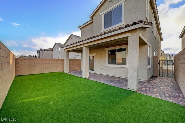 back of property with stucco siding, a lawn, a fenced backyard, and a patio area