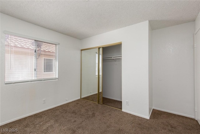 unfurnished bedroom featuring carpet flooring, baseboards, a closet, and a textured ceiling