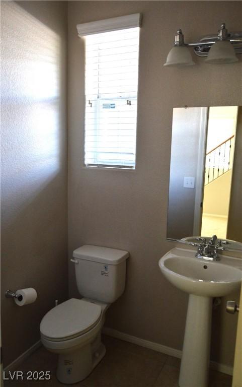 bathroom with toilet and baseboards