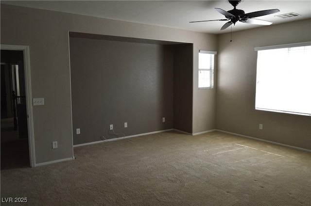 empty room with visible vents, baseboards, ceiling fan, and carpet flooring