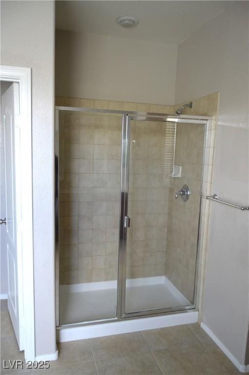 bathroom featuring tile patterned flooring and a shower stall