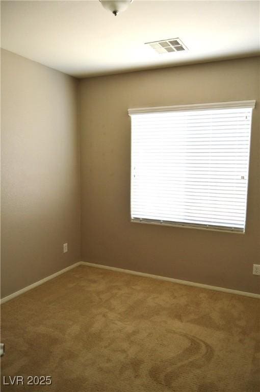 unfurnished room with visible vents, plenty of natural light, baseboards, and carpet