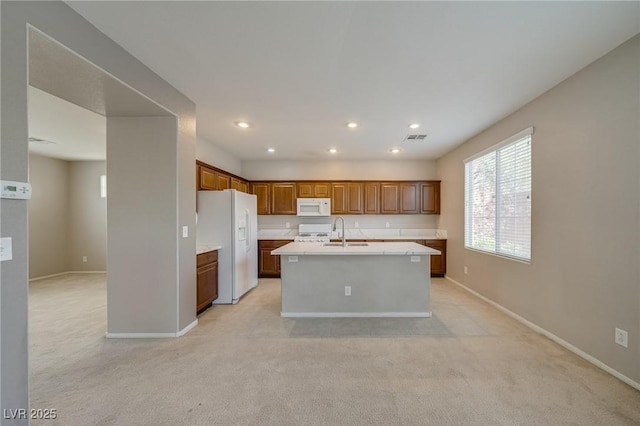 8348 Mokena Ave, Las Vegas, NV 89178 - kitchen featuring white appliances, a sink, light countertops, light colored carpet, and a center island with sink
