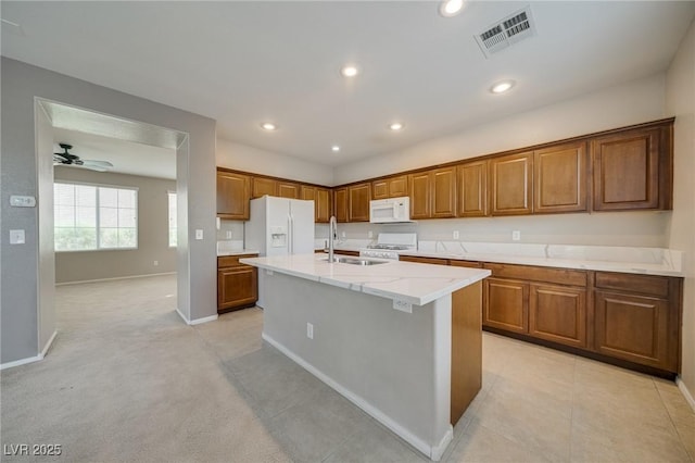 8348 Mokena Ave, Las Vegas, NV 89178 - kitchen with white appliances, a sink, brown cabinetry, a kitchen island with sink, and recessed lighting