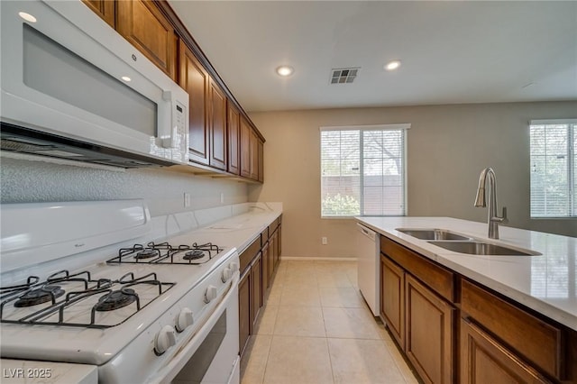 8348 Mokena Ave, Las Vegas, NV 89178 - kitchen featuring white appliances, a sink, brown cabinets, baseboards, and recessed lighting