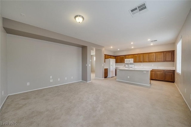 8348 Mokena Ave, Las Vegas, NV 89178 - kitchen featuring white appliances, baseboards, open floor plan, brown cabinets, and light carpet