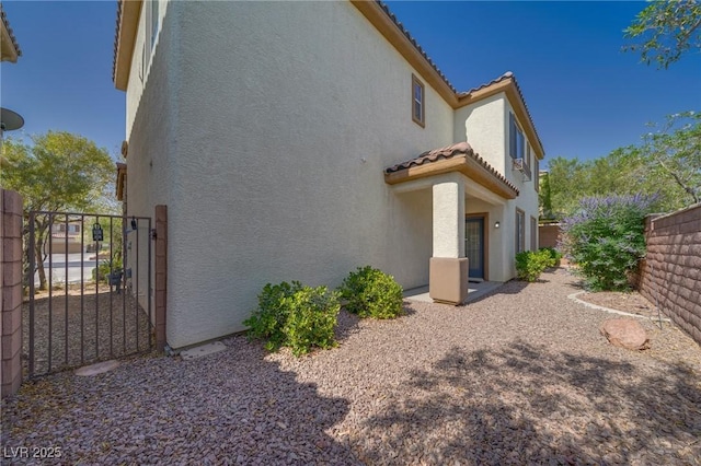 8348 Mokena Ave, Las Vegas, NV 89178 - view of home's exterior featuring stucco siding, a tile roof, and a gate