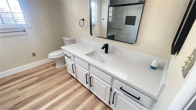 full bathroom featuring vanity, wood finished floors, plenty of natural light, a shower stall, and toilet