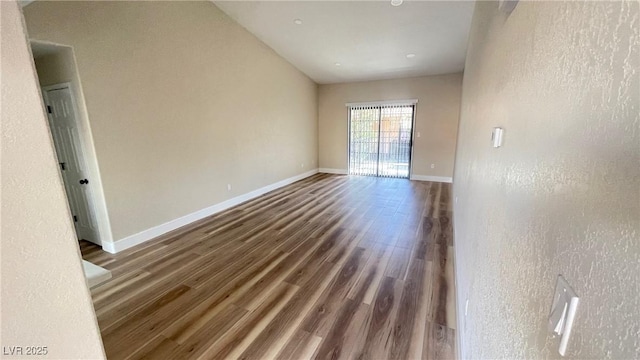 empty room with baseboards and wood finished floors