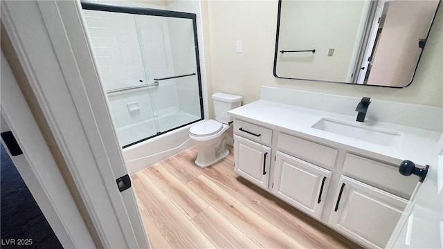 full bath with toilet, vanity, and wood finished floors