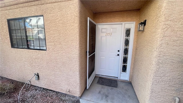 property entrance with stucco siding