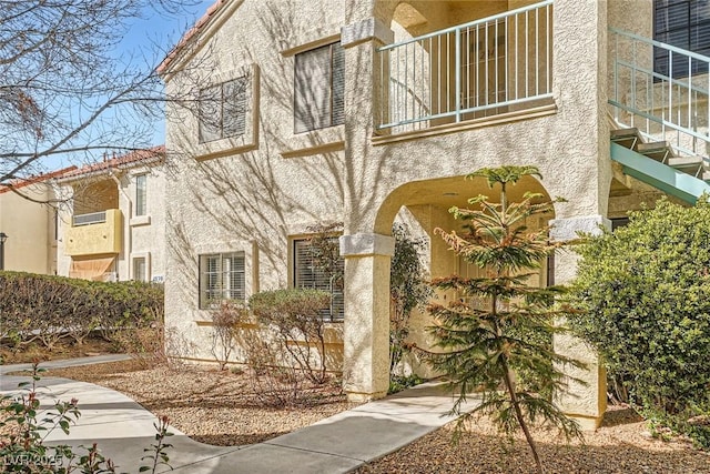 exterior space with stucco siding and a balcony