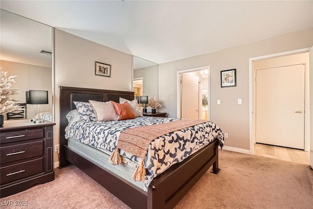 bedroom with connected bathroom, baseboards, visible vents, and light carpet