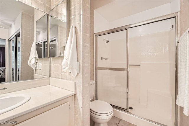 bathroom with vanity, a shower stall, toilet, and tile patterned floors