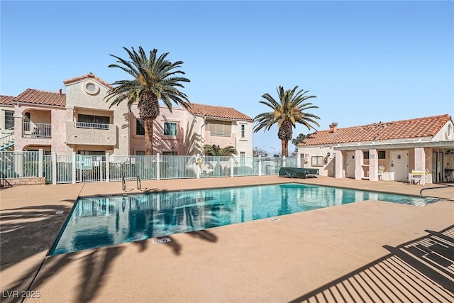 community pool with a residential view, a patio, and fence