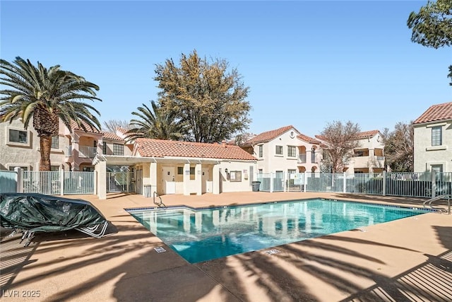 pool featuring a patio area, fence, and a residential view