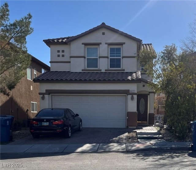 traditional-style home with a tiled roof, a garage, driveway, and stucco siding