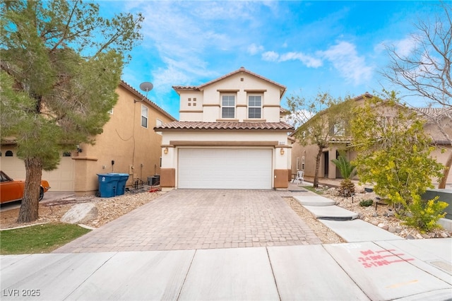 6177 W Cougar Ave, Las Vegas, NV 89139 - mediterranean / spanish home with central AC unit, stucco siding, a garage, a tile roof, and decorative driveway