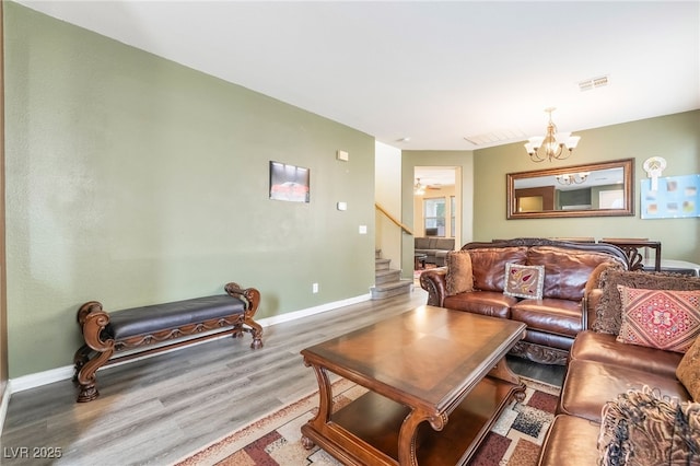 6177 W Cougar Ave, Las Vegas, NV 89139 - living room featuring visible vents, baseboards, stairs, an inviting chandelier, and wood finished floors