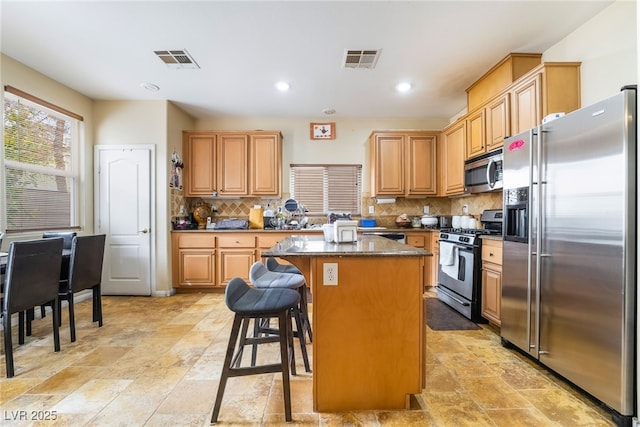 6177 W Cougar Ave, Las Vegas, NV 89139 - kitchen with a kitchen island, visible vents, backsplash, and stainless steel appliances