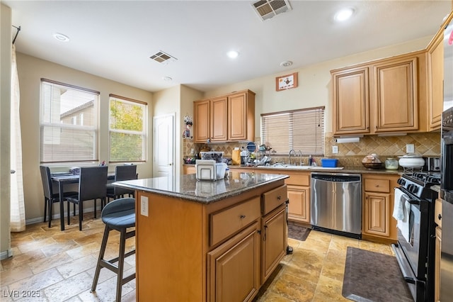 6177 W Cougar Ave, Las Vegas, NV 89139 - kitchen with stone tile flooring, visible vents, gas stove, and stainless steel dishwasher