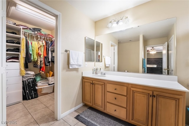 6177 W Cougar Ave, Las Vegas, NV 89139 - bathroom with vanity, baseboards, ceiling fan, a walk in closet, and tile patterned floors