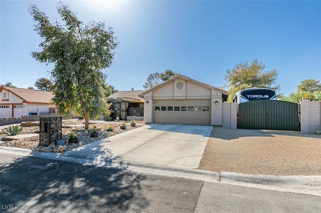 view of front of home with a garage, stucco siding, driveway, and a gate