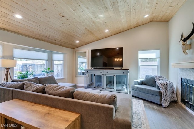 living area with a healthy amount of sunlight, lofted ceiling, a fireplace, wooden ceiling, and wood finished floors