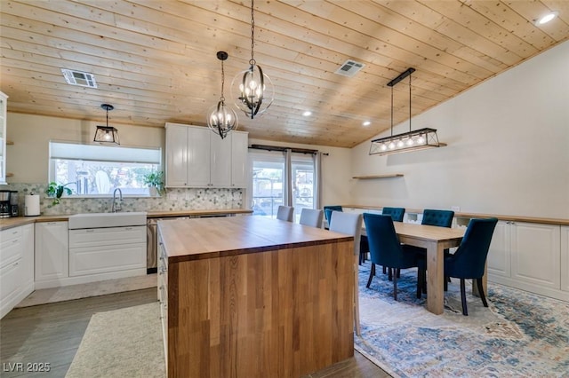 kitchen with visible vents, a sink, white cabinets, wood ceiling, and wood counters