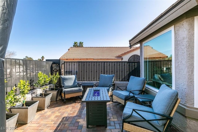 view of patio / terrace featuring an outdoor living space with a fire pit and fence