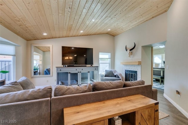 living room featuring wood finished floors, recessed lighting, vaulted ceiling, a glass covered fireplace, and wooden ceiling