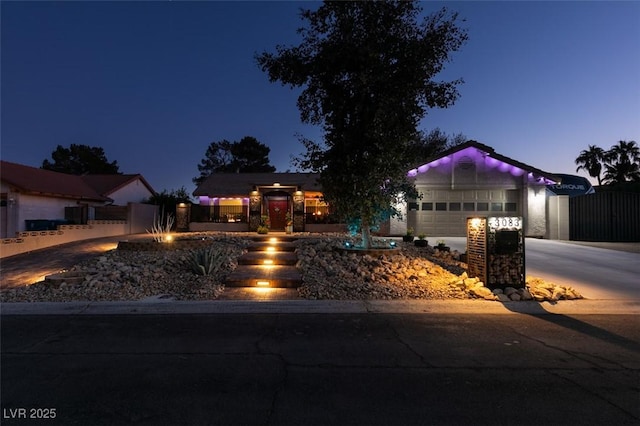 single story home featuring a garage, driveway, and fence