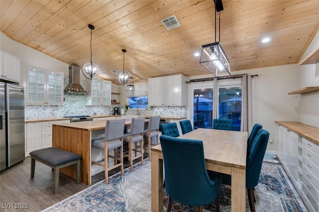 dining room featuring visible vents, vaulted ceiling, recessed lighting, wooden ceiling, and wood finished floors