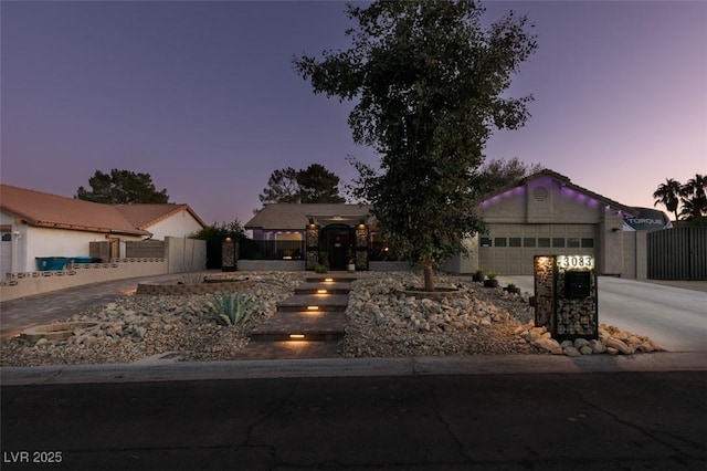 ranch-style house featuring driveway, a garage, and fence