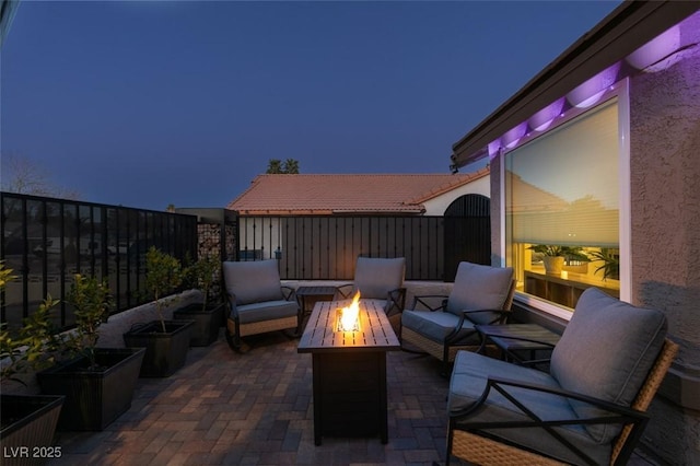 view of patio / terrace with an outdoor living space with a fire pit and fence