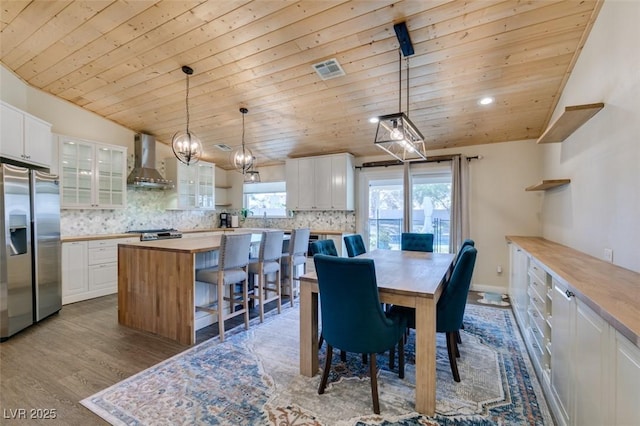 dining area featuring visible vents, wood ceiling, lofted ceiling, and wood finished floors